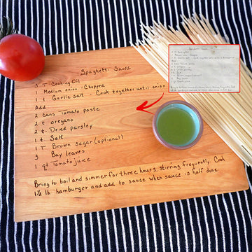 Engraved wooden recipe board with handwritten Spaghetti Sauce text, shown beside a small image of the original recipe card and a red arrow.
