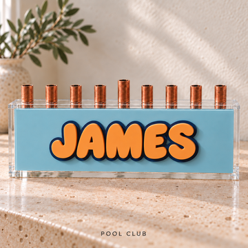 The Classic personalized acrylic menorah in Pool Club with raised orange JAMES lettering, a pale blue panel and nine candle cups