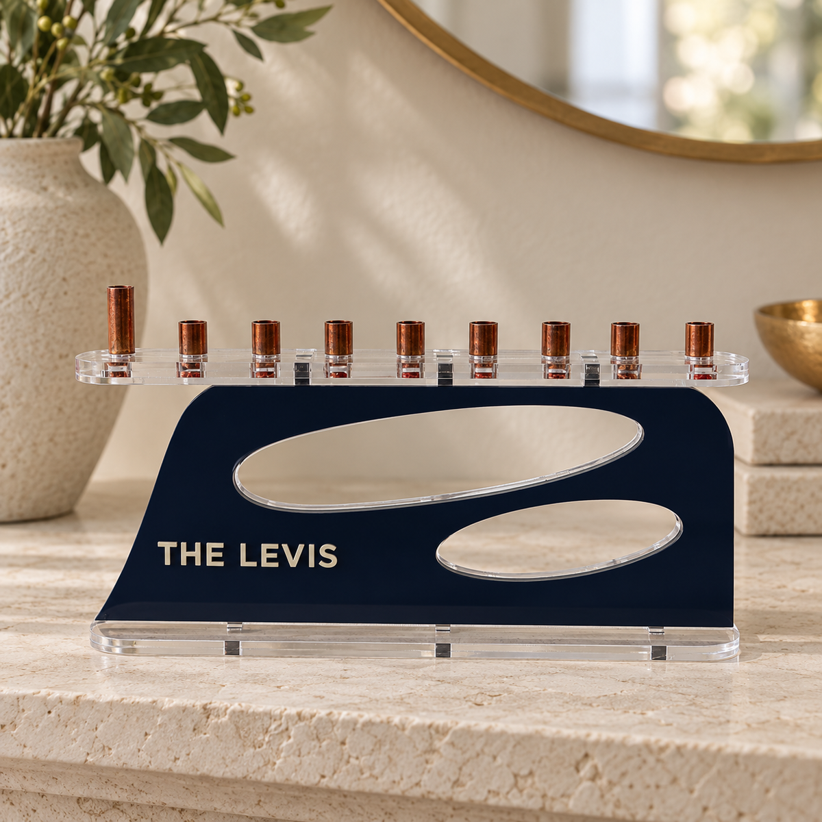 The Aperture personalized acrylic menorah in Navy and Linen, with THE LEVIS lettering, two oval openings, clear base and copper candle cups