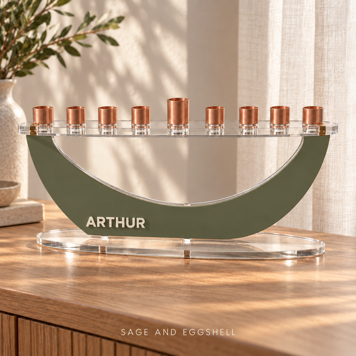 ARTHUR acrylic Crescent menorah in Sage and Eggshell, with a curved front and clear oval base on an oak console