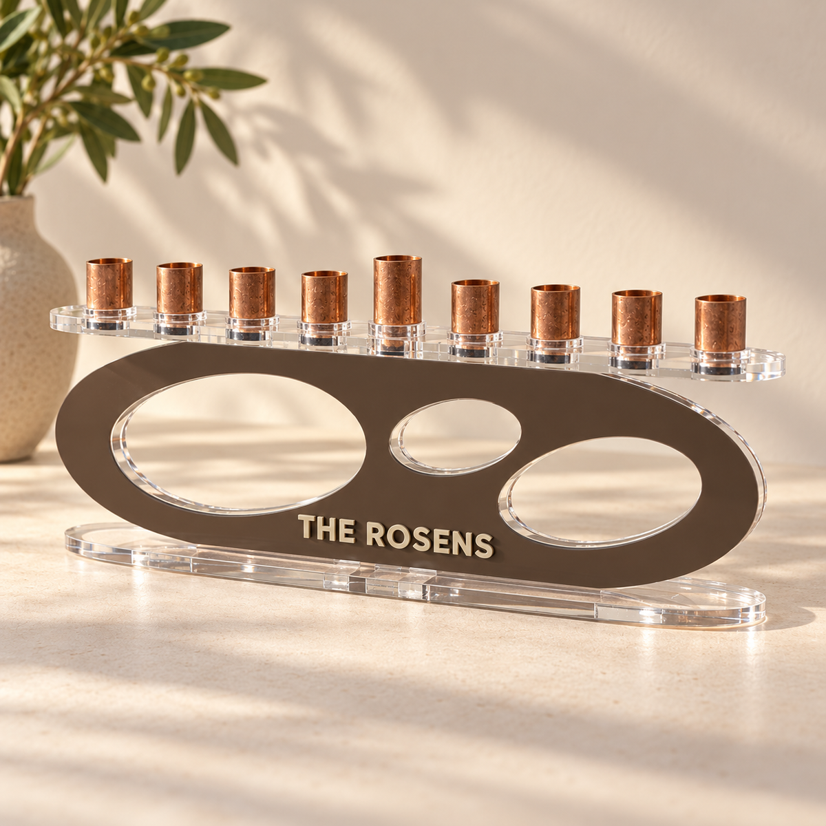 THE ROSENS personalized Forma menorah in Milk Chocolate with Linen lettering, clear oval base and copper candle cups