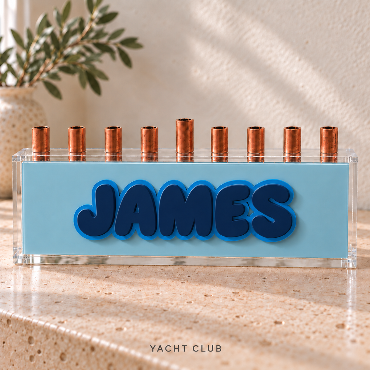 The Classic personalized acrylic menorah in Yacht Club: Ice panel, Earth Toned Navy JAMES letters, Light Blue outlines and clear box.