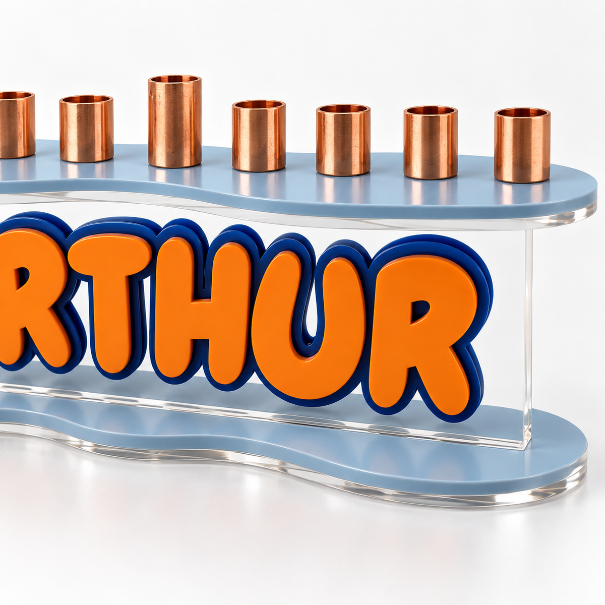 Close-up of The Contour showing layered orange and navy lettering, clear acrylic panel, curved pale blue plates and copper cups