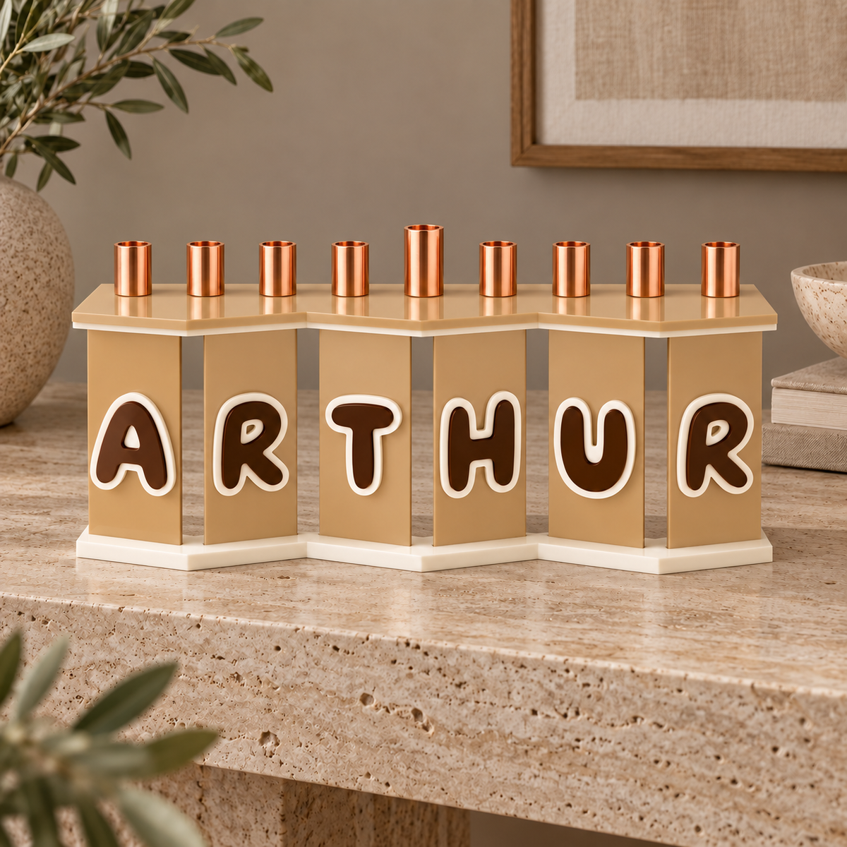ARTHUR custom name menorah in beige, brown and cream on a travertine console