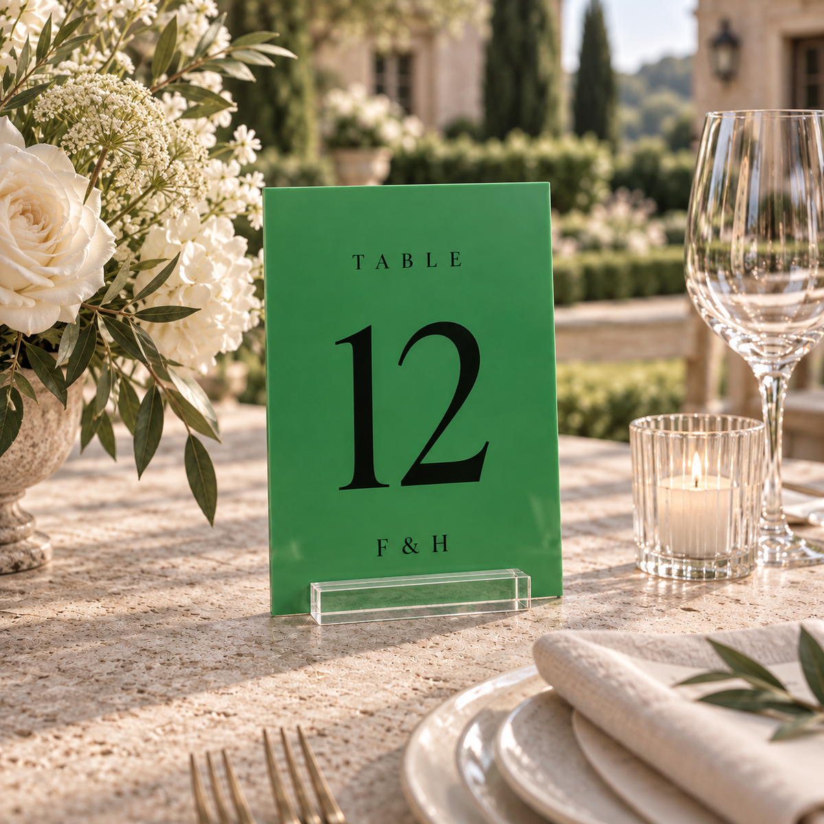 green rectangular acrylic wedding table number 12 with personalized initials in a clear stand on a reception table