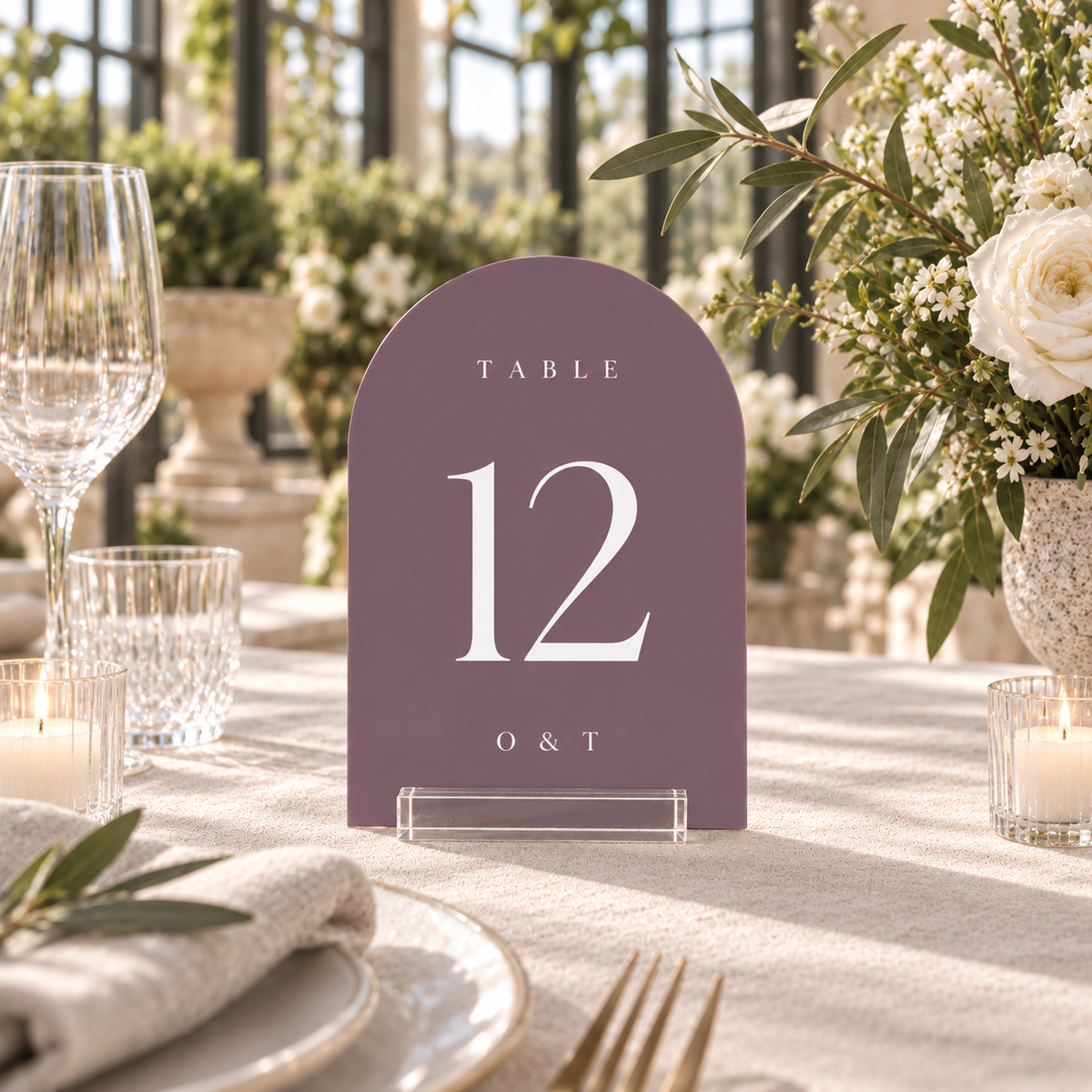 wisteria arched acrylic wedding table number 12 with personalized initials in a clear stand on a reception table