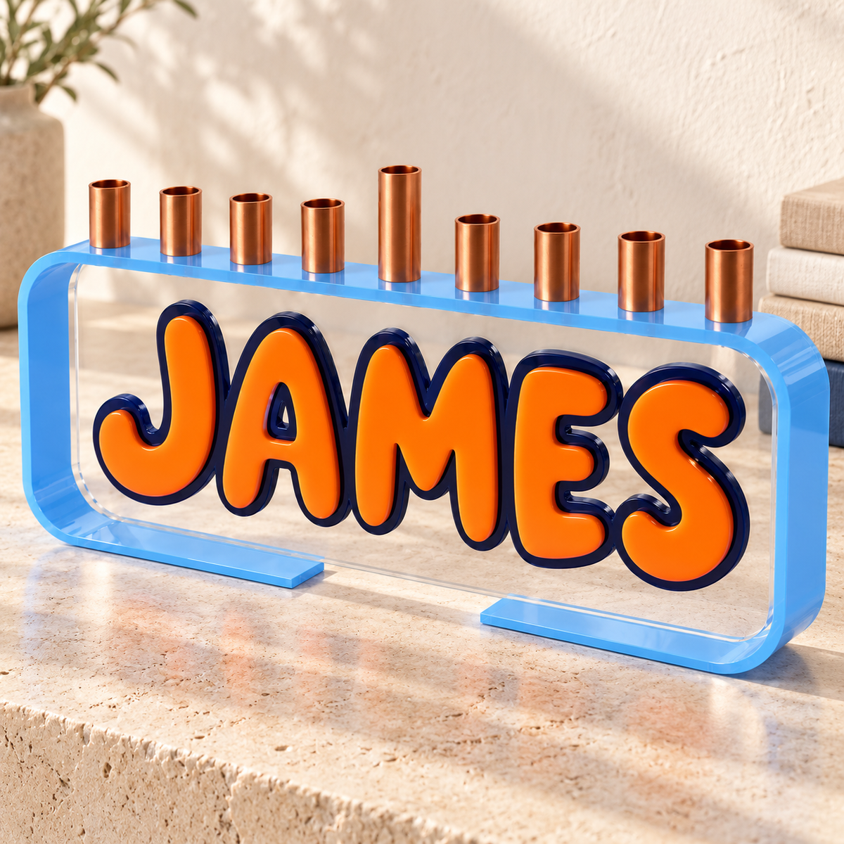 JAMES Loop menorah with light blue frame and orange lettering on limestone