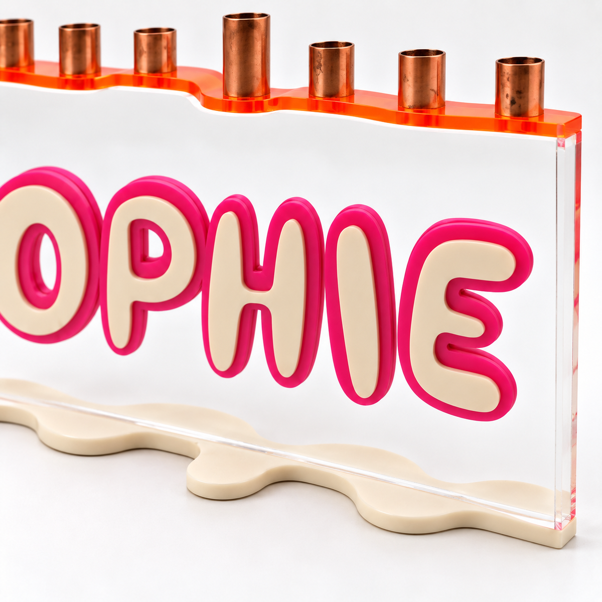Close-up of layered SOPHIE lettering, clear acrylic and copper candle cups on The Wave menorah