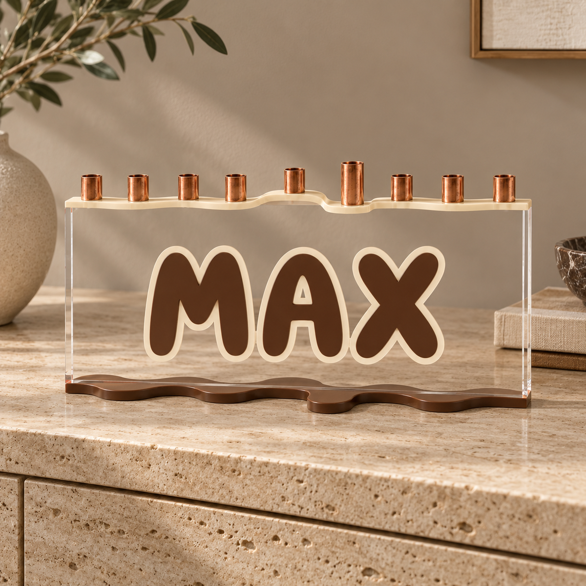 MAX personalized menorah in neutral Teddy colors on a travertine console