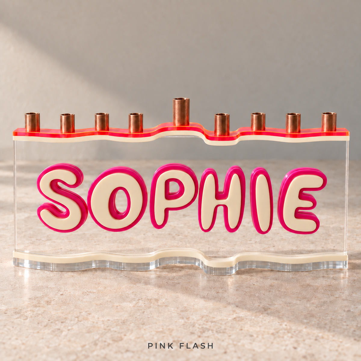 The Wave personalized SOPHIE menorah in Pink Flash, with a Neon Pink/Orange top, Eggshell letters and base, Fuchsia outlines and clear acrylic.