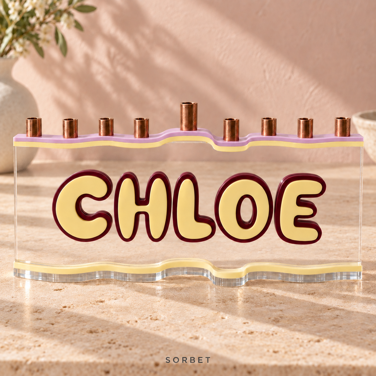 CHLOE custom acrylic menorah in Sorbet, with Strawberry Milk soft pastel pink-lilac top, Lemon Chiffon soft pale yellow letters and matching base, Wine deep burgundy outlines and clear acrylic.